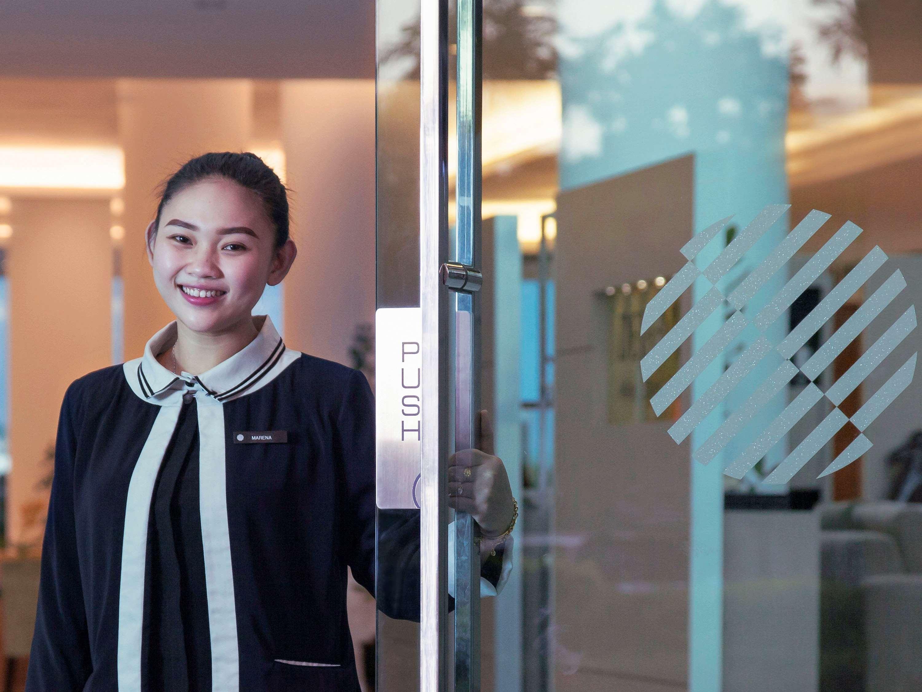 โรงแรมพูลแมน กูชิง ภายนอก รูปภาพ A Thai woman working at a hotel